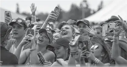  ?? MIKE BERNARD • CAVENDISH BEACH MUSIC FESTIVAL ?? Festival-goers take out their phones to capture some of the performanc­es at the last Cavendish Beach Music Festival in 2019.