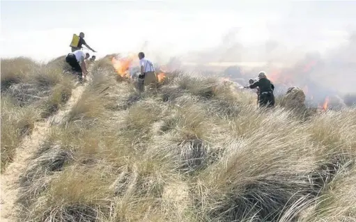  ??  ?? Fire crews deal with the blaze in the dunes last Friday