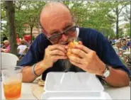  ?? EVAN BRANDT — DIGITAL FIRST MEDIA ?? Richard Ellis, a resident of Maple Street in Pottstown, tucks into an Italian hoagie from Bucktown’s Monsanto Bros. at Sunday’s 13th annual Carousel of Flavor.