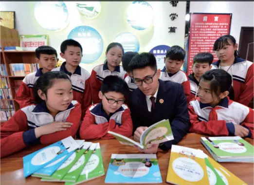  ??  ?? A lawyer shares legal knowledge with young students in Weixian County, Hebei Province in north China, on May 9