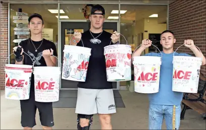  ?? / Ross Rogers ?? College and Career Academy students Jacob Flemister (from left), Sean Brown and Cody Holloway hold up some of the buckets that they and their classmates assembled for the Floyd County Sheriff’s Office’s RomeGaCare­s relief effort.