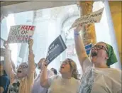  ?? Justin Wan Lincoln Journal Star ?? NEBRASKANS protest a bill that limits genderaffi­rming care for trans youth Friday in Lincoln.