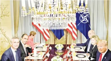  ??  ?? Stoltenber­g (left) and Trump (right) wait with staff before a breakfast meeting at the US chief of mission’s residence in Brussels ahead of a Nato summit. — AFP photo