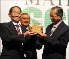  ??  ?? Yuan (left) receives the 2011 Mahathir Science Award from former Malaysian prime minister Mahathir Mohamad (right) on Jan 31, 2012 in Kuala Lumpur.