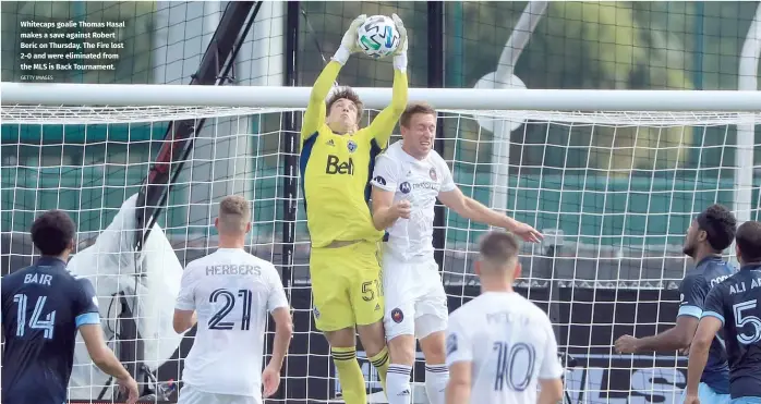  ?? GETTY IMAGES ?? Whitecaps goalie Thomas Hasal makes a save against Robert Beric on Thursday. The Fire lost 2-0 and were eliminated from the MLS is Back Tournament.