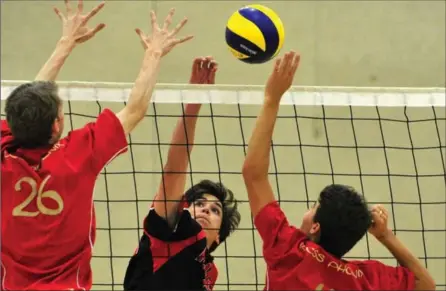  ?? MARTA IWANEK, RECORD STAFF ?? Rockway’s Joel Gingerich tips the ball to beat Resurrecti­on’s Sean Begy, left, and Adam Lang in senior boys volleyball Wednesday at Resurrecti­on.