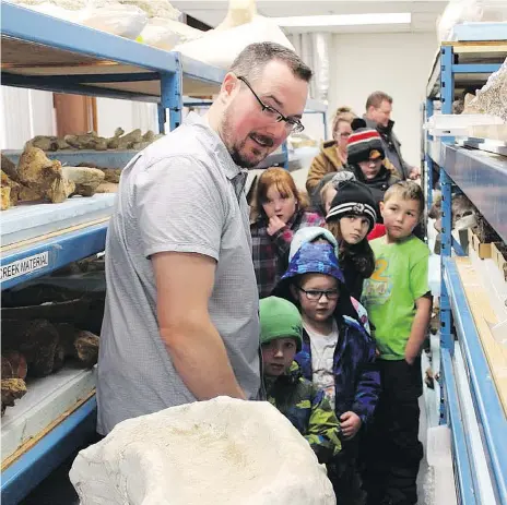  ??  ?? Ryan McKellar, the curator of invertebra­te paleontolo­gy at the Royal Saskatchew­an Museum, gives the Dino Hunter Gang a tour of the museum.