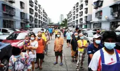  ??  ?? Residents of the Klong Toei slum community queue for food boxes made by Michelinst­arred chefs.