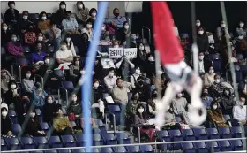  ?? HIRO KOMAE — THE ASSOCIATED PRESS ?? Audience members cheer for Wataru Tanigawa of Japan as he competes in the rings during an internatio­nal gymnastics meet Nov. 8 in Tokyo.