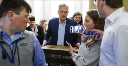  ?? PATRICK SEMANSKY/AP ?? House Speaker Kevin McCarthy, R-Calif., carries food for members of the press covering debt limit negotiatio­ns Saturday on Capitol Hill in Washington. House negotiator­s left the Capitol after 2 a.m. Saturday and returned hours later.