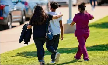  ?? Cooper Neill / New York Times ?? Families reunite with students from Timberview High School on Wednesday at the Mansfield ISD Center for the Performing Arts, in Mansfield, Texas, after a shooting at the high school in Arlington, Texas, left four people injured, authoritie­s said.