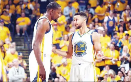  ?? NATHANIEL S BUTLER/NBAE/GETTY IMAGES/AFP ?? Kevin Durant and Stephen Curry of the Golden State Warriors speak during the game against the Cleveland Cavaliers in Game 2 of the 2017 NBA Finals on June 4 at Oracle Arena in Oakland, California.