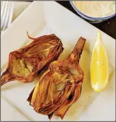  ??  ?? Artichoke halves fried in olive oil can be served with mayonnaise for dipping and wedges of fresh lemon.
