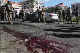  ?? MOHAMMED ZAATARI — THE ASSOCIATED PRESS ?? Lebanese army soldiers gather around a damaged car near the coastal town of Jadra, south Lebanon, Saturday, Feb. 10, 2024. An apparent Israeli drone strike hit a car near Lebanon’s southern port city of Sidon Saturday killing at least two people and wounded others, security officials said.