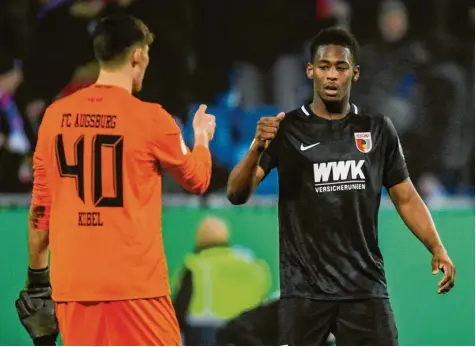  ?? Foto: dpa ?? FCA-Neuzugang Reece Oxford (rechts, hier beim Abklatsche­n mit Torhüter Gregor Kobel) war einer der herausrage­nden Spieler beim 1:0-Sieg der Augsburger gegen den Zweitligis­ten Holstein Kiel. Damit stehen die Augsburger im Viertelfin­ale des DFB-Pokals.