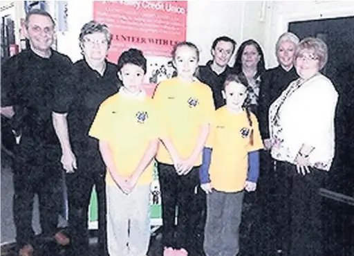  ??  ?? John Hughes and other Llynfi Valley Credit Union volunteers with pupils at Plasnewydd Primary School in Maesteg