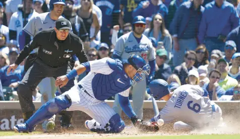  ?? NUCCIO DINUZZO/GETTY ?? Trea Turner of the Los Angeles Dodgers is safe at home against Willson Contreras during the fifth inning of game one of Saturday’s doublehead­er.