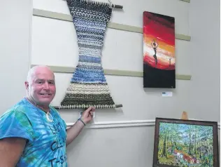  ?? PHOTO: BEN WATERWORTH ?? Community Art . . . Riverton Community Arts Centre chairman Wayne Hill shows some of the art on display at the Riverton Summer Art Feast.