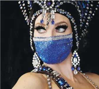  ??  ?? A showgirl wears a face mask at the reopening of Bally’s Las Vegas hotel and casino this week. Not since shoes or underwear has a single item of dress caught on so widely and quickly.