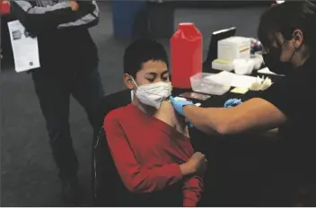  ?? JAE C. HONG/AP ?? JOHNNY THAI (11) RECEIVES THE PFIZER COVID-19 VACCINE at a pediatric vaccine clinic for children ages 5 to 11 set up at Willard Intermedia­te School in Santa Ana, Calif., on Nov. 9, 2021.