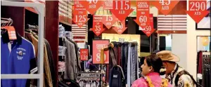  ?? Photo by Shihab ?? A couple looks at the shopping discounts ahead of the festival on Tuesday. —