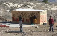  ?? (Marc Israel Sellem/The Jerusalem Post) ?? AMONA RESIDENTS daub protest slogans against the government on the wall of a soon-to-be demolished building.