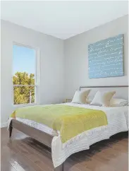  ??  ?? UPSTAIRS: One of three brightly lit bedrooms upstairs with weathered solid red oak flooring that is featured throughout the condo.