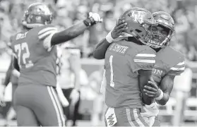  ?? Karen Warren / Staff photograph­er ?? Bryson Smith, center, celebrates a UH touchdown earlier this season. He’s part of one of the most high-powered offenses in the country, averaging 52.3 points.