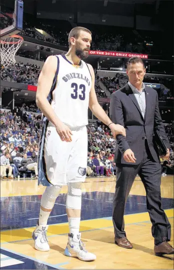 ?? NIKKI BOERTMAN/THE COMMERCIAL APPEAL ?? Grizzlies head athletic trainer Drew Graham (right) helps center Marc Gasol of f the cour t during the first quar ter. Gasol lef t the game with a right mid-foot injur y and did not return, and the Griz lost to the Trail Bla zers in over time 112-106.