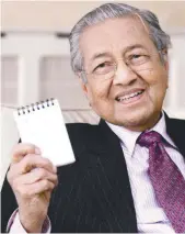  ??  ?? Mahathir showing his personal notebook on tasks for Cabinet members during a press conference in London on Monday.