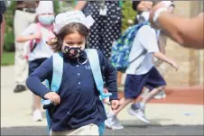  ?? Ned Gerard / Hearst Connecticu­t Media ?? Anna Miller runs to greet her mother at the end of the first day of school at Holy Trinity Catholic Academy in Shelton on Monday.