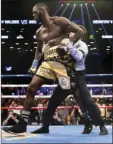  ?? PHOTO/KEVIN HAGEN ?? A referee pulls Deontay Wilder away from Bermane Stiverne after Wilder knocked out Stiverne during the WBC Heavyweigh­t World Championsh­ip fight Saturday in New York. AP