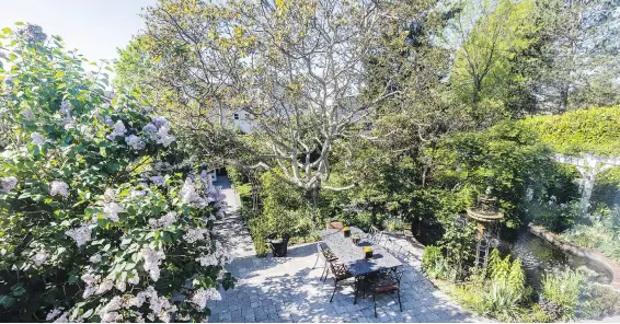  ?? ?? The view from the dining room takes in the huge walnut tree, new patio, staircase and full accessible pathway down to a tiny cottage and pond at right.