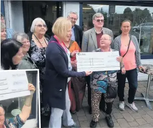  ??  ?? ●●Karen Gaskell presenting a cheque to the Olive Branch and celebratin­g the amount raised, left