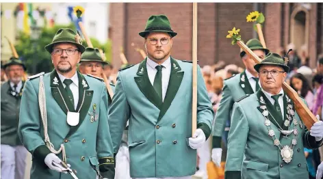  ?? FOTO: JANA BAUCH ?? Der Ernst des Lebens: Seitenoffi­zier Hans Jürgen, Autor Rasche, Zugkönig Frank (v.l.) marschiere­n bei der Königspara­de am Pfingstson­ntag.