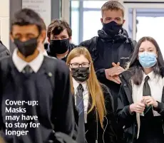  ??  ?? Cover-up: Masks may have to stay for longer