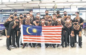  ?? — Bernama photo ?? Malaysia U23 team pose with the Jalur Gemilang at the Kuala Lumpur Internatio­nal Airport yesterday as they leave for the Hanoi SEA Games.