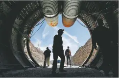  ?? ASSOCIATED PRESS FILE PHOTO ?? People walk into the south portal of Yucca Mountain during a 2015 congressio­nal tour of the proposed radioactiv­e waste dump near Mercury, Nev., 90 miles northwest of Las Vegas. The plan to store waste there was on hold until the Trump administra­tion revived it.