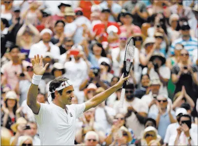  ?? Tim Ireland ?? The Associated Press Top-seeded Roger Federer acknowledg­es the crowd after defeating Italy’s Adrian Mannarino in straight sets in their
Wimbledon men’s fourth-round singles match Monday in London.