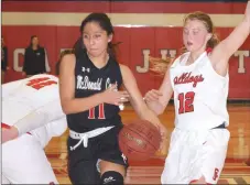  ?? RICK PECK/SPECIAL TO MCDONALD COUNTY PRESS ?? McDonald County’s Rita Santillan splits Carl Junction’s Megan Scott (42) and Shila Winder (12) on her way to the basket during the Lady Mustangs’ 51-23 loss on Feb. 22 at Carl Junction High School.