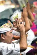  ?? GALIH COKRO/JAWAPOS ?? ENAM BULAN SEKALI: Umat Hindu bersembahy­ang di Pura Agung Jagat Karana, Rabu malam (30/5). Foto kanan, mereka dihibur pertunjuka­n topeng monyer.