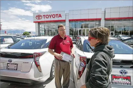  ?? RICK BOWMER / AP ?? Mary Jean Jones speaks with salesman Doug Lund at a Toyota dealership in Salt Lake City. Instead of buying a vehicle, more Americans are shifting to leasing, which allows drivers to utilize a new or used car for a limited amount of time.