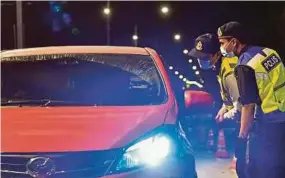  ?? BERNAMA PIC ?? Policemen speaking to a motorist at a roadblock in Putrajaya on Sunday. Six of the 13 Covid-19 clusters involving interstate travel detected since last month had originated from Selangor.