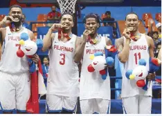  ??  ?? Moala Tautuaa, Jason Perkins, CJ Perez and Chris Newsome (from left) savor the gold following their victory over Thailand in yesterday’s finals. Left photo shows Tautuaa going strong to the hoop. MICHAEL VARCAS