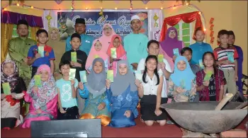  ??  ?? (Back row, from third left) Usop, Suraya and Mohamad Alias join other teachers and children, who received cash donations earlier, in a group photo.