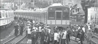  ?? HARITSAH ALMUDATSIR/JAWA POS ?? KEMBALIKAN KE REL: Sejumlah petugas dan teknisi PT KAI memperbaik­i KRL yang anjlok di Depo Stasiun Jatinegara kemarin.