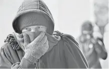  ?? Will Dickey / Florida Times-Union via Associated Press ?? Chris McGuire tries to stay warm as he waits for a space Tuesday at the City Rescue Mission in Jacksonvil­le, Fla.