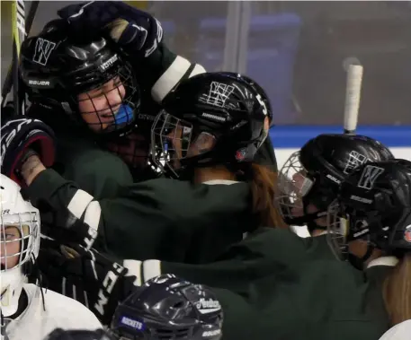  ?? JIM MICHAUD / BOSTON HERALD ?? ‘SHOWING UP ON THE ICE’: Westwood’s Caroline Shu (left) receives congratula­tions from Ainsley Campbell (5) and teammates for scoring in the second period as the Wolverines and Rockets skated to a 1-1 tie.