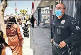 ?? Genaro Molina Los Angeles Times ?? LAPD SGT. Kenneth Price watches as Jews head to temple Saturday on La Brea.
