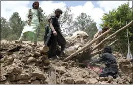  ?? THE ASSOCIATED PRESS ?? Afghan villagers collect belongings from under the rubble of a home that was destroyed in an earthquake in Khost province, Afghanista­n, on Wednesday.